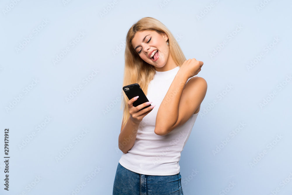 Teenager girl over isolated blue background points finger at you while smiling Teenager girl over isolated blue background points finger at you while smiling