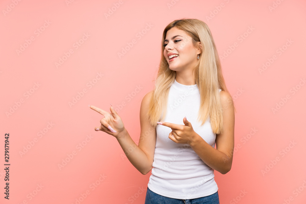 Teenager girl over isolated pink background pointing finger to the side Teenager girl over isolated pink background pointing finger to the side