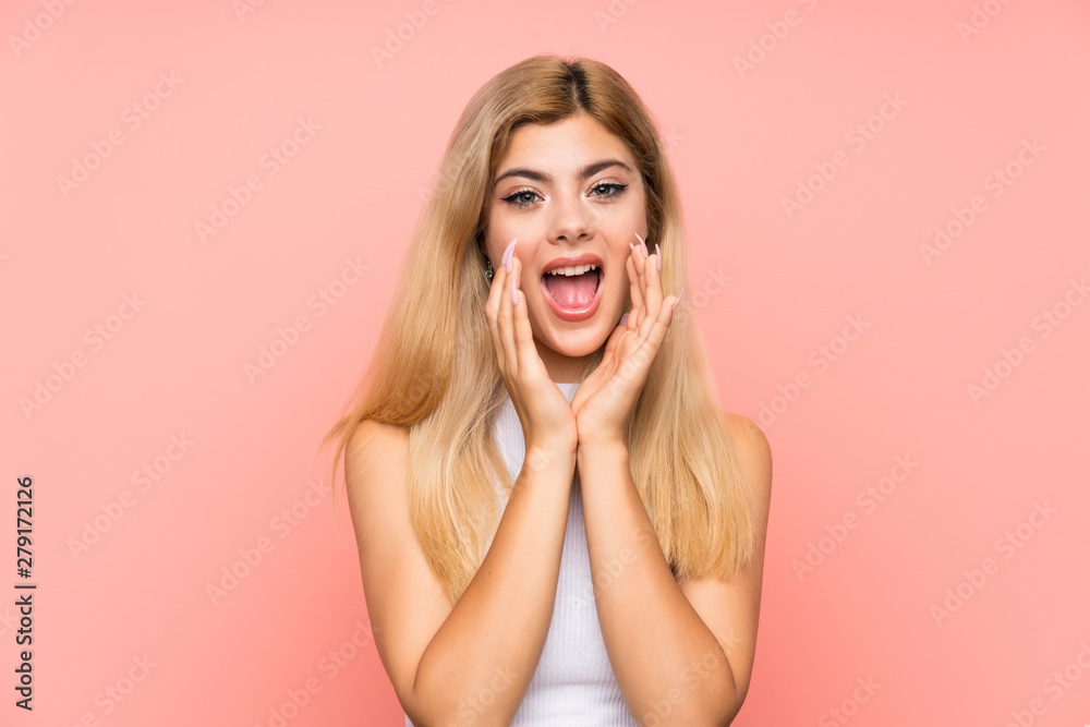 Teenager girl over isolated pink background shouting with mouth wide open Teenager girl over isolated pink background shouting with mouth wide open