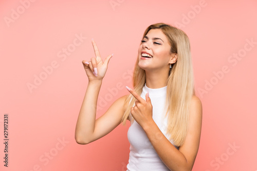 Teenager girl over isolated pink background pointing with the index finger a great idea