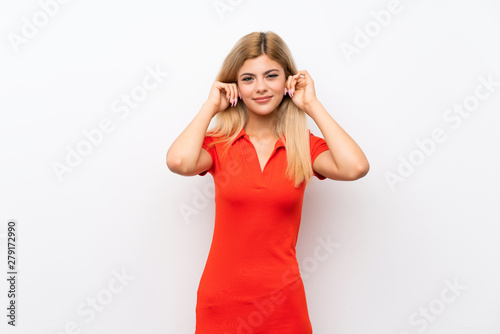 Teenager girl over isolated white background frustrated and covering ears © luismolinero