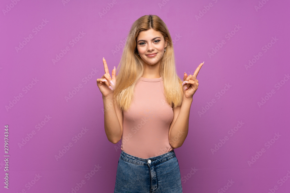 Teenager girl over isolated purple background pointing up a great idea Teenager girl over isolated purple background pointing up a great idea