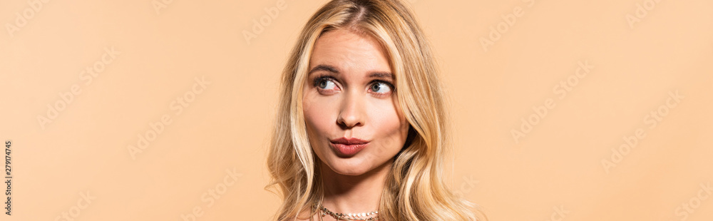 curious blonde woman looking away isolated on beige curious blonde woman looking away isolated on beige