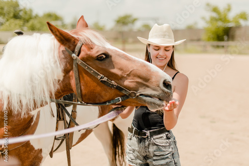 country girl feeding a horse on a ranch