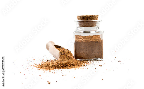 milled or ground nutmeg in wooden scoop and jar on isolated on white background. front view. spices and food ingredients.