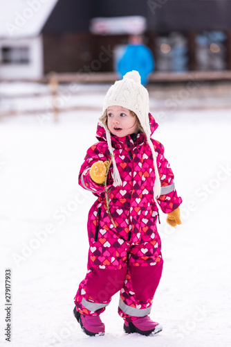 little girl having fun at snowy winter day