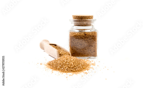 Brown or cane sugar in wooden scoop and jar on isolated on white background. front view. spices and food ingredients.