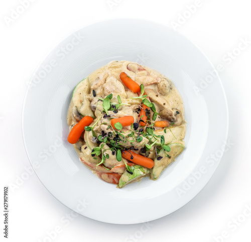 Hot salad with chicken meat, carrots, mushrooms, zucchini and cheese sauce isolated on white background. Healthy food, top view