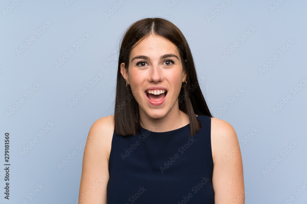 Fototapeta premium Young woman over isolated blue wall with surprise facial expression