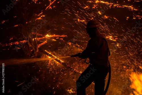 Wildland firefighter battling wildfire with ember shower