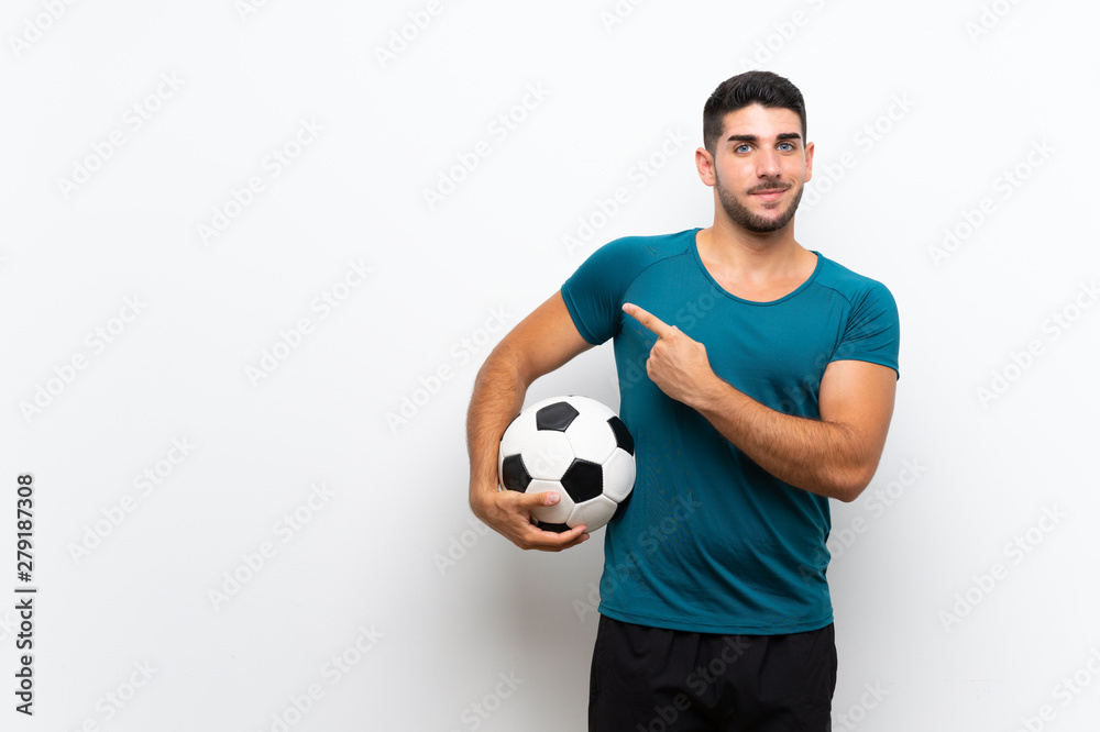 Handsome young football player man over isolated white wall pointing to the side to present a product