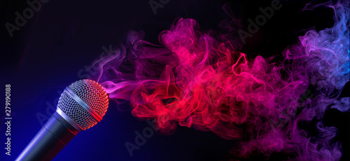 microphone in a purple-bluish smoke on black background