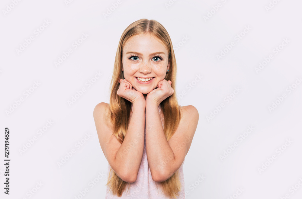 Close up portrait of happy attractive and cute blonde little girl with long hair while she is posing isolated in studio and smiling Close up portrait of happy attractive and cute blonde little girl with long hair while she is posing isolated in studio and smiling