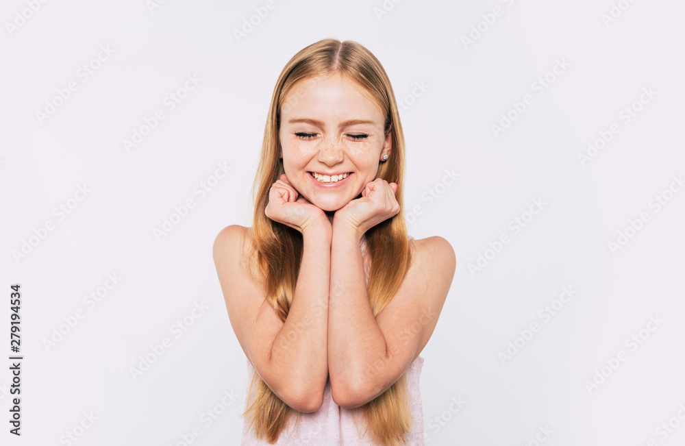 Close up portrait of happy attractive and cute blonde little girl with long hair while she is posing isolated in studio and smiling Close up portrait of happy attractive and cute blonde little girl with long hair while she is posing isolated in studio and smiling