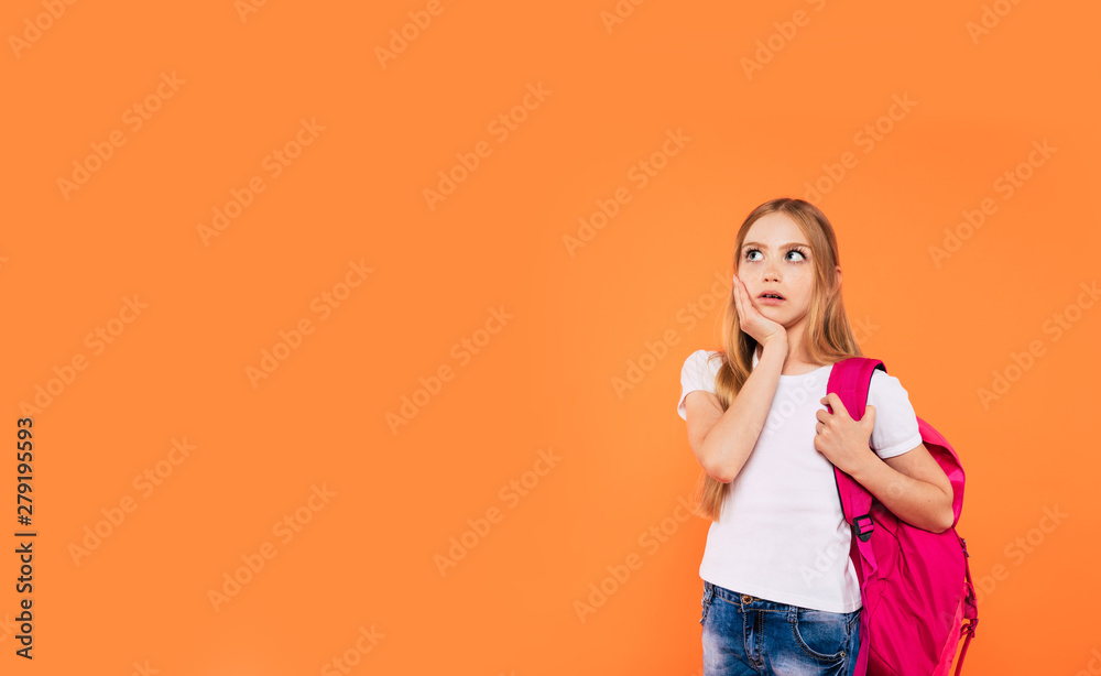 Beautiful smiling and happy school girl with backpack is posing on yellow background Beautiful smiling and happy school girl with backpack is posing on yellow background