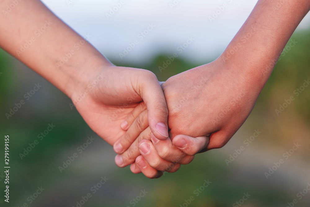 Two girl holding hand and walking on the road. Young women couple on the beautiful landscape. Two girl holding hand and walking on the road. Young women couple on the beautiful landscape.