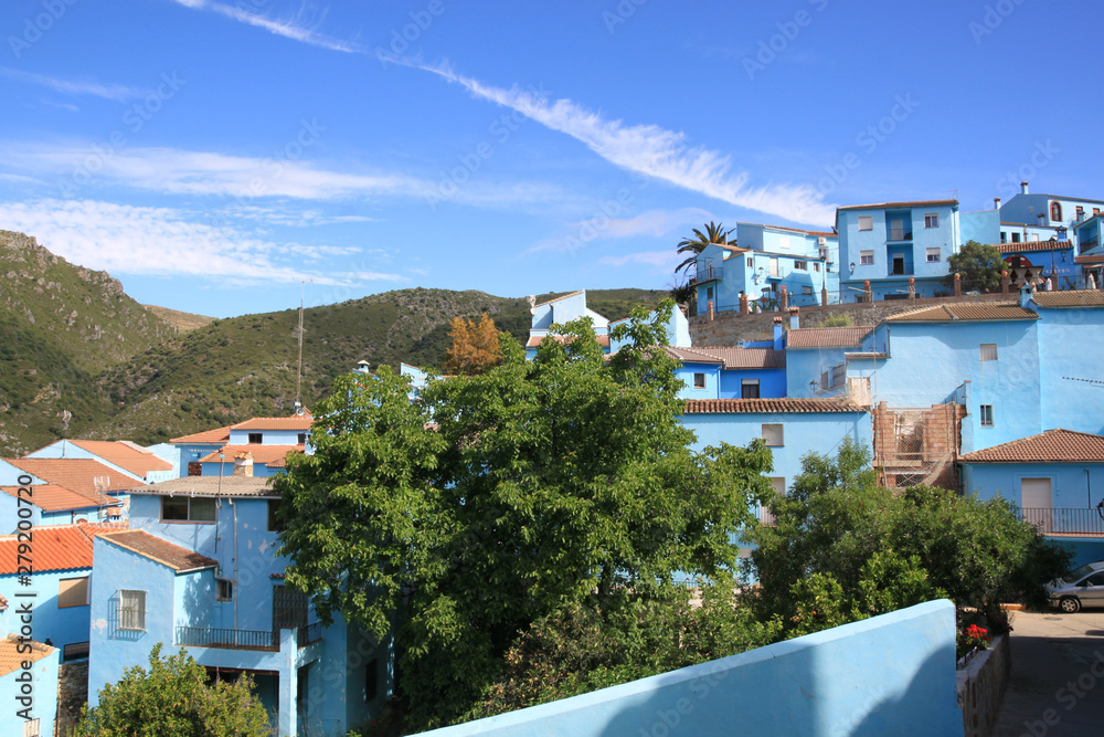 blue houses in Spain in Malaga, Jucar in the mountain with a tree in front of it