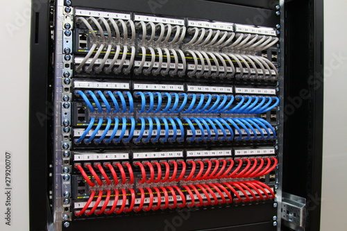 Ethernet switches connected by patch cords to patch panels in the colors of the flag of Russia. Installed in a telecommunications rack.