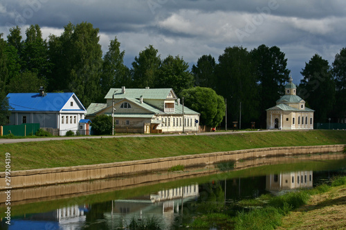 Embankment of Tikhvinka river in Tikhvin.  Family house of the Russian composer N. A. Rimsky - Korsakov and Church of All Saints  photo