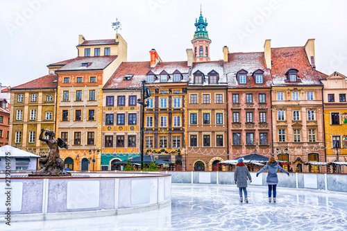Two girls skate on a skating rink in the Old town square in Warsaw on the eve of Christmas, Poland