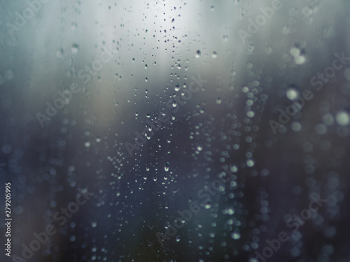 ..Raindrops on the surface of window glass with a blurred background.