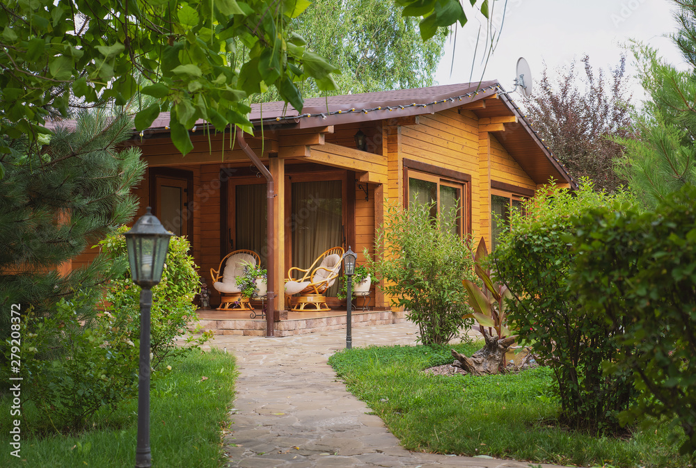 Fototapeta premium Domki wiejskie z bali i drewnem na zielonym terenie. przytulne ekologiczne domy z naturalnego drewna, bungalowy dla rodzin