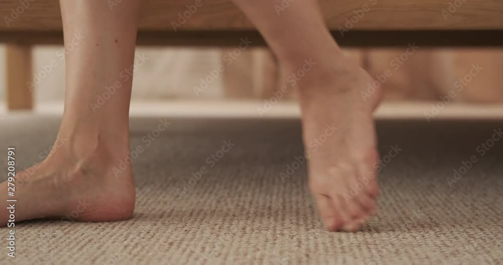 Bare feet of woman getting out of the bed and walking Bare feet of woman getting out of the bed and walking