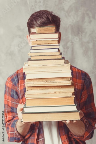 Young boy student hold many books. Guy want learning, have education. online education. Study in school. Male prepare for lessons. Electronic library, e-book concept