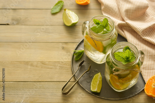 Homemade lemonade with lime, mint in a mason jar on a wooden rustic table. Summer drinks. Copy space.
