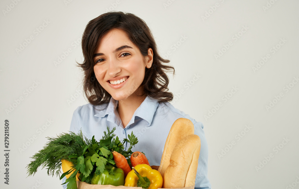young woman holding shopping bag full of groceries young woman holding shopping bag full of groceries