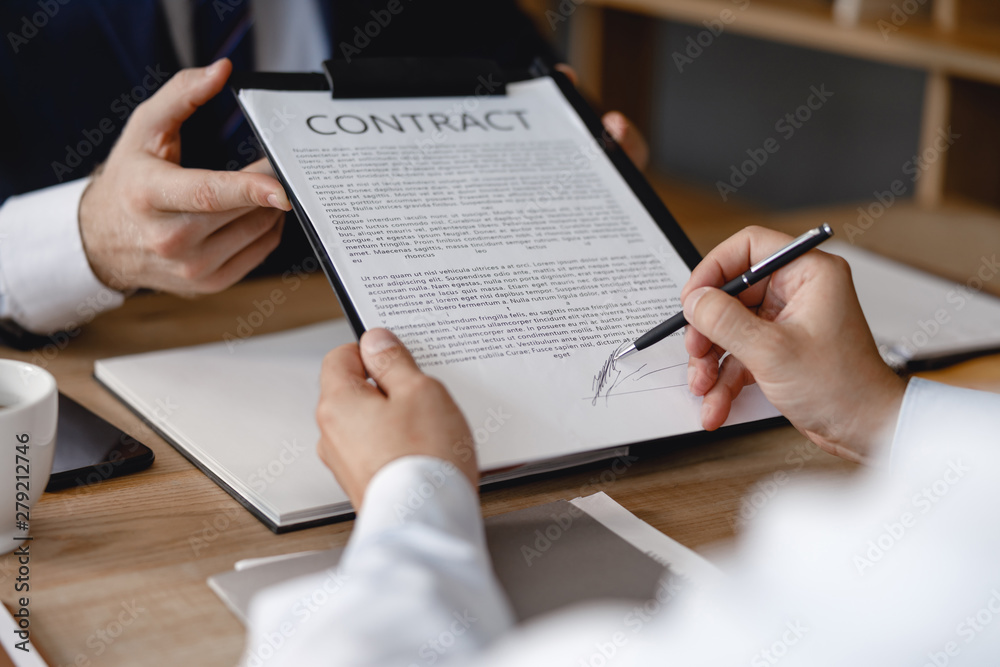 Hand of person signing contract with his partner in the office