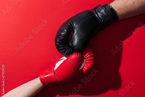 cropped view of man and woman in boxing gloves on red © LIGHTFIELD STUDIOS