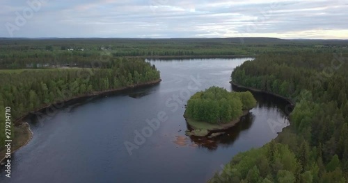Aerial, drone shot, the Tornionjoki river, overlooking small islands and spruce tree forest, on a sunny day, in Pello, Meri-Lappi, Lapland, Finland photo