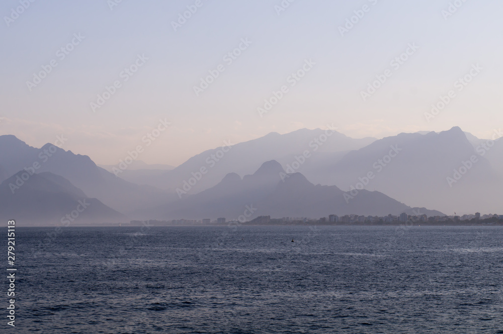 Mountains in a blue haze and sunset over the sea