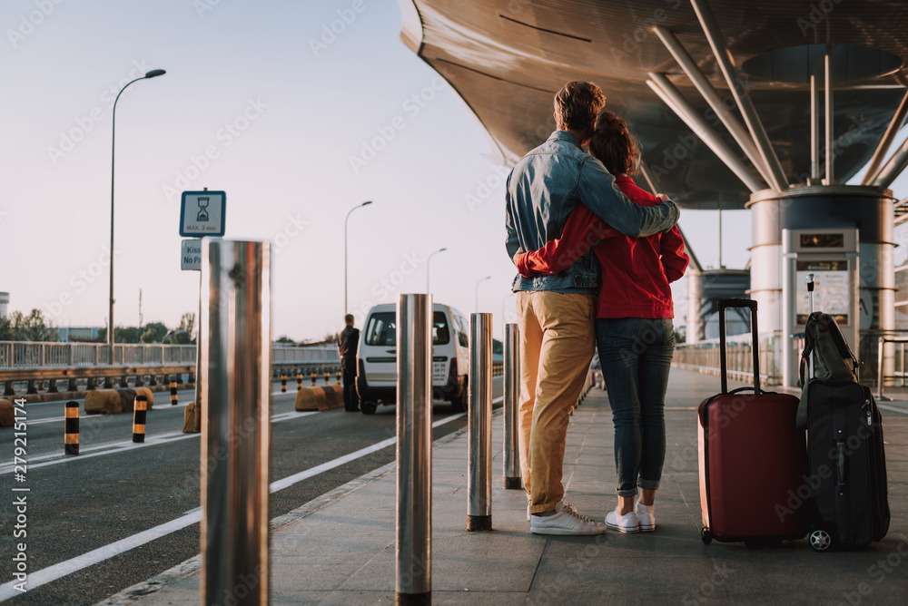 Loving couple with travel bags hugging on the street Loving couple with travel bags hugging on the street