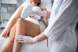 Close up lady on laser epilation procedure of legs