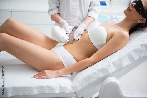 Lady on laser epilation procedure of belly zone