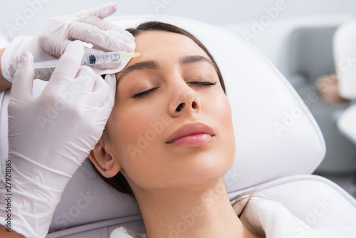 Specialist is making procedure to young lady
