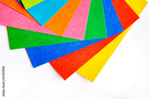 Many various colorful sheets of cardboard on a white background, top view