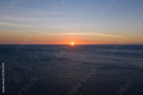 Sunset over the sea in clear weather, view from above. Seascape with evening sun and deep blue sea. © Tatiana Nurieva