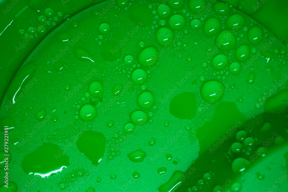 Water drops on green background close up
