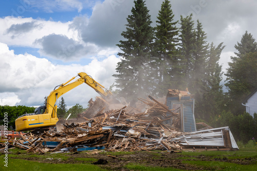 heavy duty machine demolishing a wood building