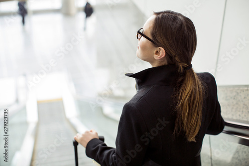 Blond woman standing on escalator at railroad station