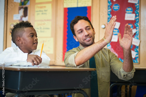 Billede på lærred Male teacher explaining concept to schoolboy (8-9)