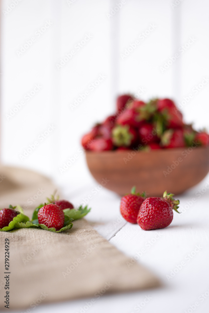 ripe and tasty berries lie on the table, green strawberry leaf and ripe berries ripe and tasty berries lie on the table, green strawberry leaf and ripe berries