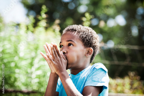 Canvas Print Boy (8-9) whistling through blade of grass