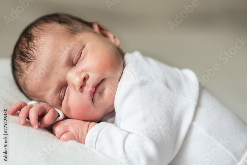 infant newborn baby dressed in white 