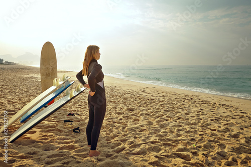 Canvas Print Side view of woman in wetsuit standing on beach
