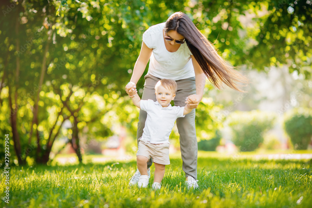 Walk in park mom and son, first step, learn to go child. Concept family