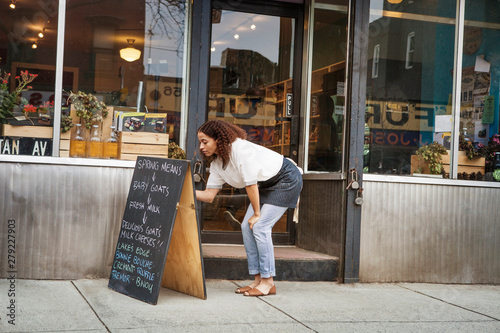 Photography Small business owner writing on blackboard